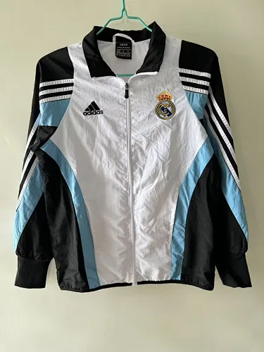 Cazadora del Real Madrid de los días 25 y 26, en blanco, negro y azul